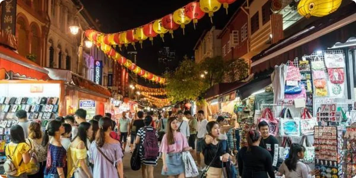 A bustling Chinatown street filled with diverse pedestrians and vibrant storefronts, showcasing cultural activity and community life.