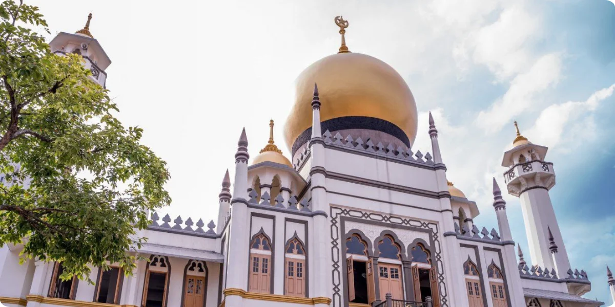 A stunning view of the Sultan Mosque in Kampong Glam, Singapore, showcasing its golden dome and intricate architectural details.