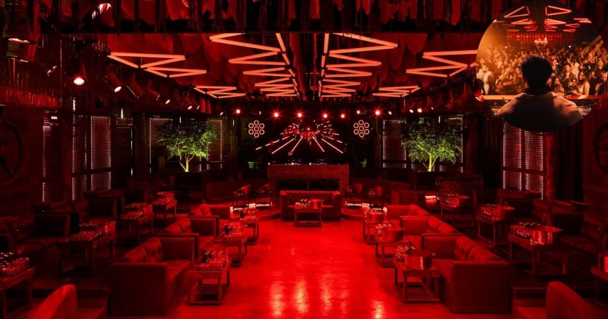 A stylish interior view of Bonbonniere Tulum, a popular nightclub, featuring a futuristic DJ booth with a large, vibrant glowing cube and a crowd of people enjoying the music and light show.