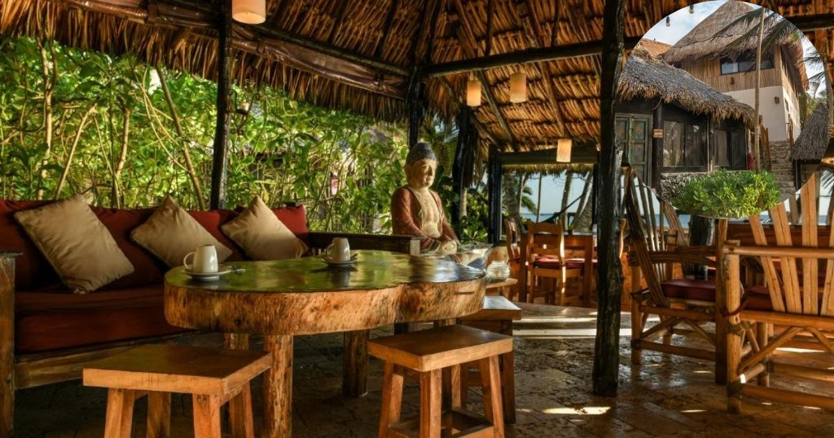 The rustic and tranquil beachfront of Diamante K hotel in Tulum, featuring traditional thatched-roof cabanas, hammocks, and a sandy path leading towards the turquoise Caribbean Sea.