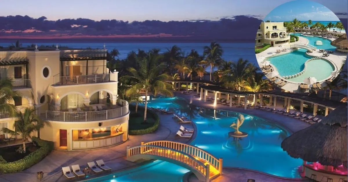 A stunning nighttime view of the Dreams Tulum Resort & Spa, showcasing its beautifully illuminated freeform pools, a lit-up fountain, and the luxury all-inclusive hotel buildings at dusk.