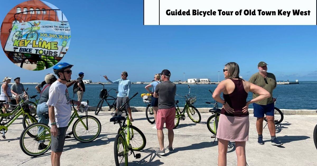 A group of tourists with bicycles on a guided bike tour of Old Town Key West, Florida, with the ocean in the background.