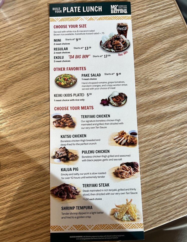 A clear, vertical photo of a Mo' Bettahs "Build Your Plate Lunch" menu, showing options for plate sizes (Mini, Regular, Ekolu), a variety of meats like Teriyaki Chicken, Kalua Pig, and Shrimp Tempura, and other items like drinks and catering.