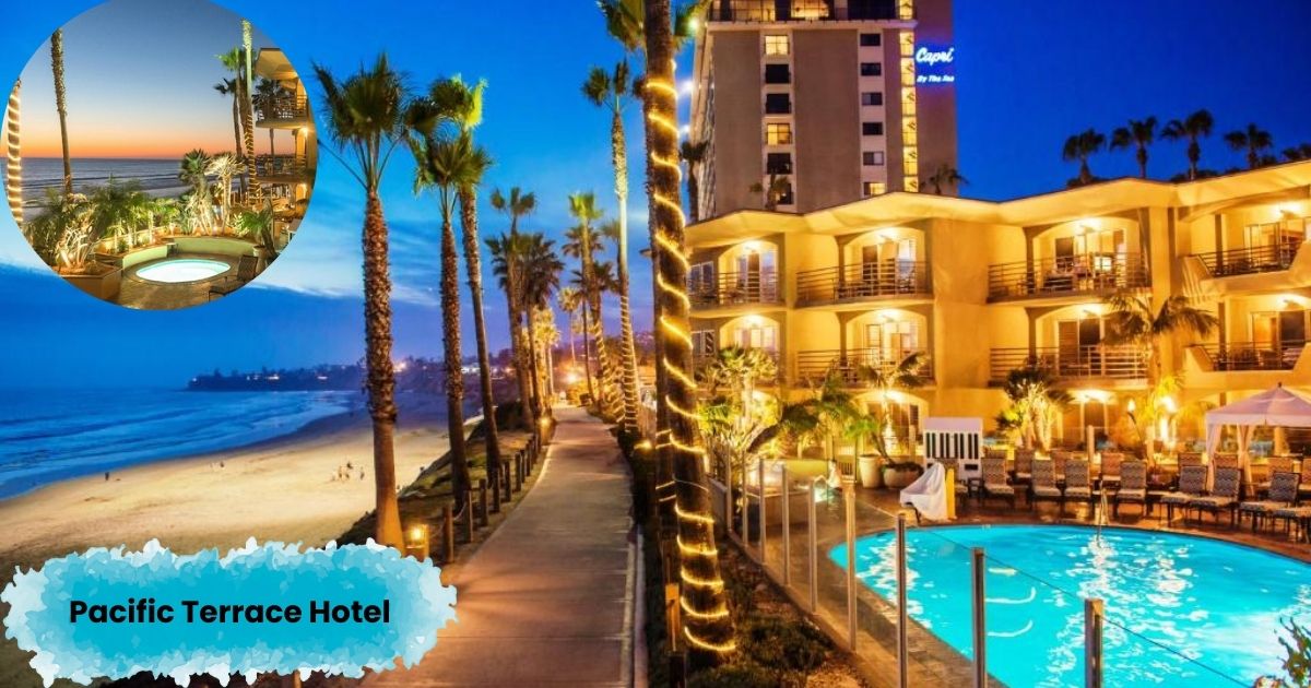 A beautiful nighttime photo of the Pacific Terrace Hotel, showing the lit-up buildings and swimming pool. The photo, taken at dusk, shows a path lined with palm trees and a view of the beach and ocean at sunset.