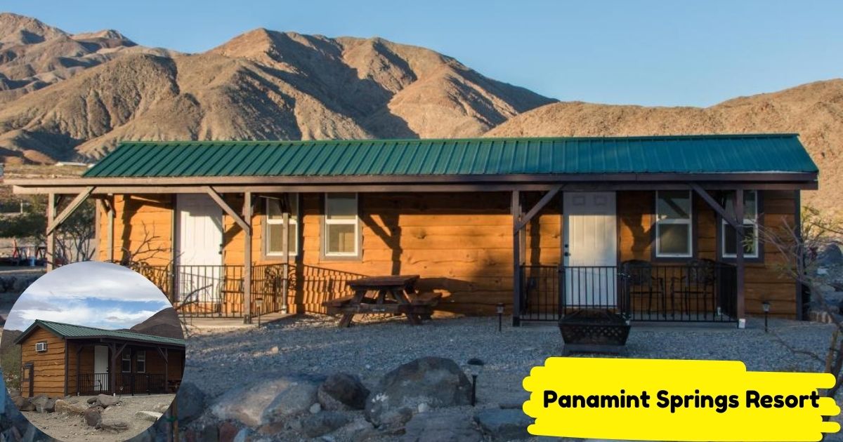 A front-facing photo of a rustic, wood-paneled cabin at Panamint Springs Resort with a green metal roof, set against a backdrop of rocky, desert mountains and a clear blue sky.
