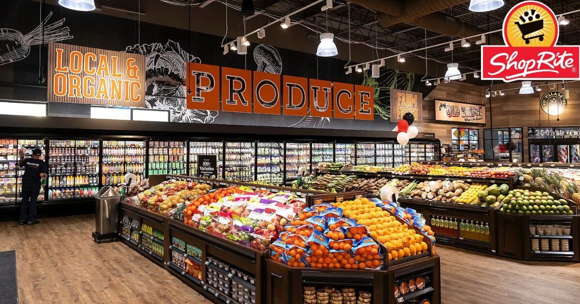 The interior of a ShopRite supermarket with shoppers pushing carts down a clean aisle.
