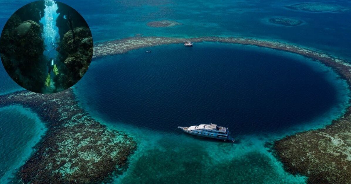 An aerial view of The Great Blue Hole, a large, dark blue circle in the middle of a lighter blue ocean, with a diving boat visible.