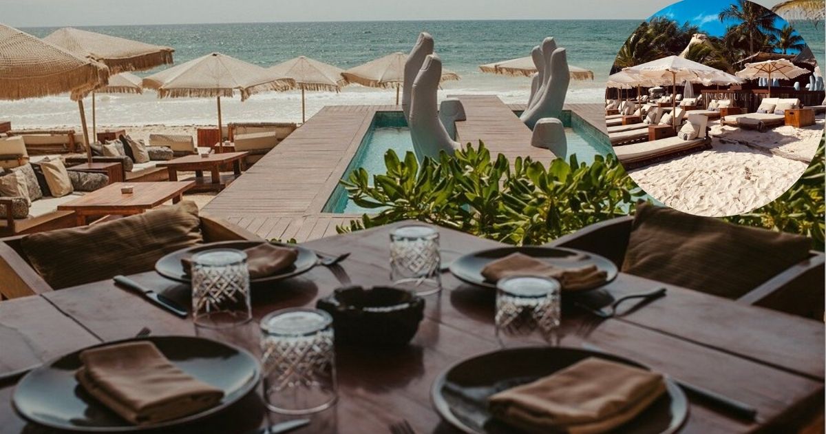 A stunning nighttime view of Vagalume Tulum, a popular beach club and restaurant, featuring an illuminated outdoor lounge area with stylish seating and unique decor, surrounded by lush trees and a serene atmosphere.