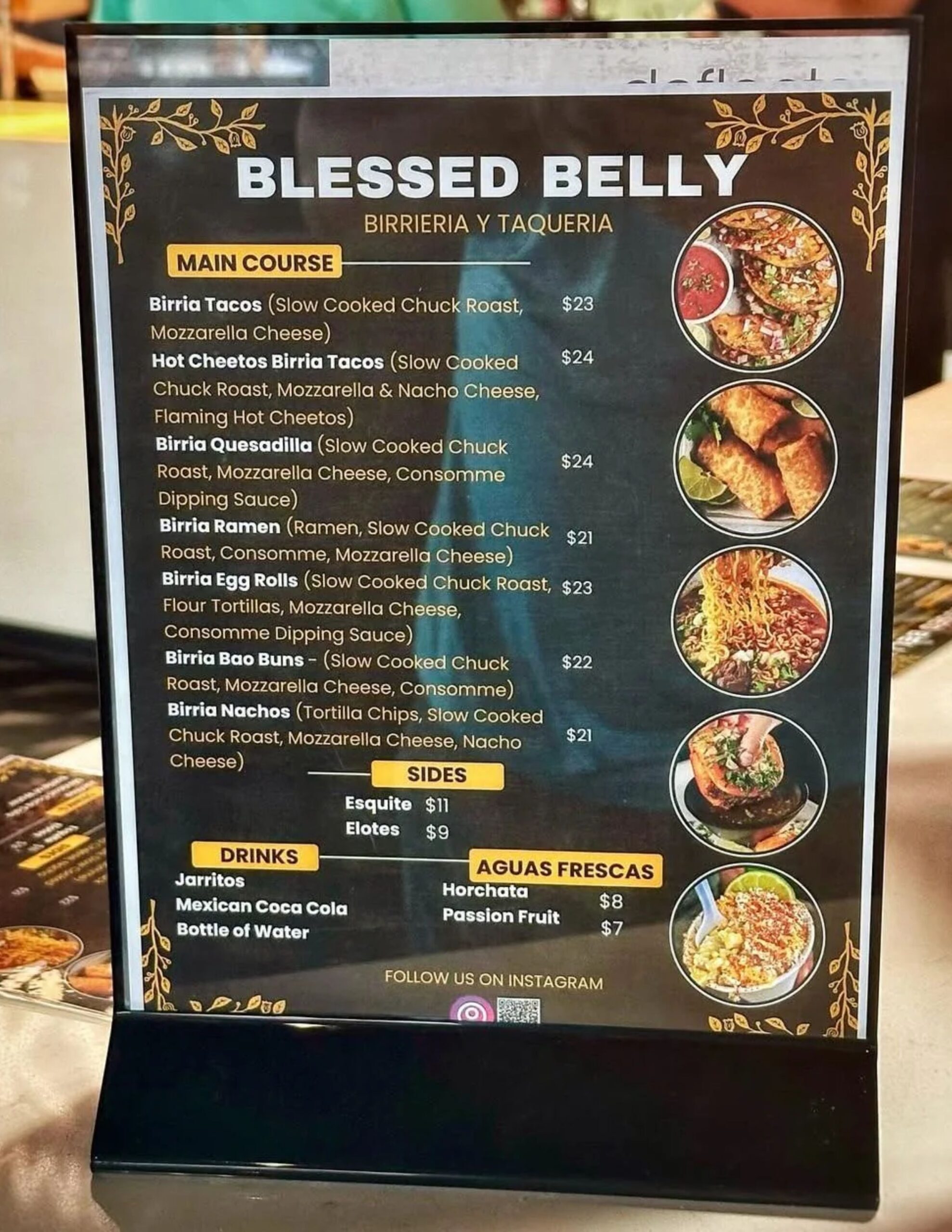 A vertical menu for "Blessed Belly Birrieria y Taqueria," showcasing a main course menu with Birria Tacos, Birria Ramen, and Birria Nachos. The menu also lists Sides, Drinks, and Aguas Frescas, with corresponding photos of each dish.