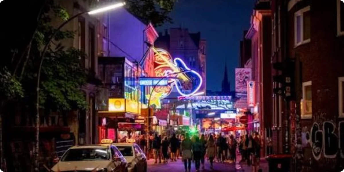  A vibrant San Juan street at night, illuminated by neon signs, with people strolling and enjoying the lively atmosphere.