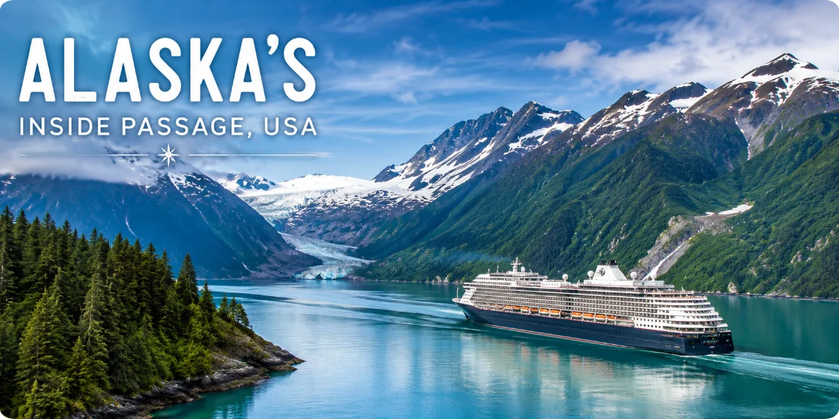 Scenic view of Alaska's Inside Passage, showcasing lush forests and tranquil waters under a clear blue sky.