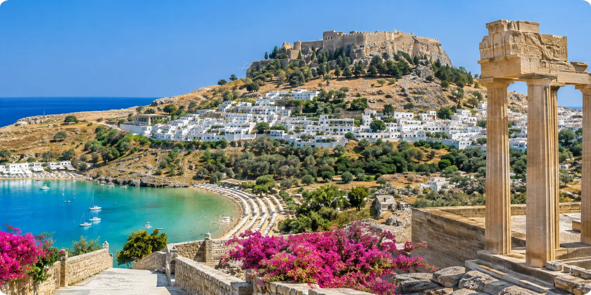 A picturesque landscape of Rhodes, highlighting white structures and the stunning blue waters of the Mediterranean.