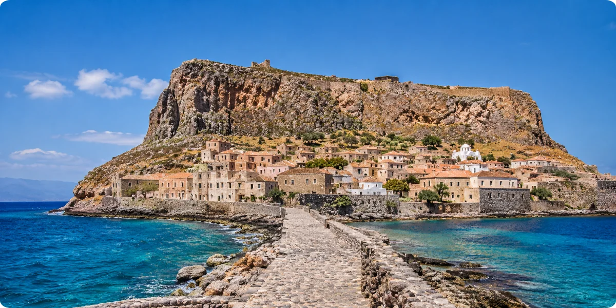 Aerial view of Monemvasia, showcasing its historic architecture and coastal landscape against the backdrop of the sea.