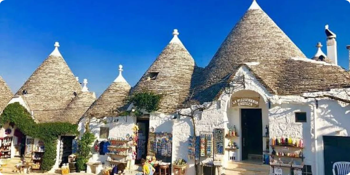 Trulli houses in Alberobello, Puglia, Italy, featuring conical roofs and whitewashed stone walls.