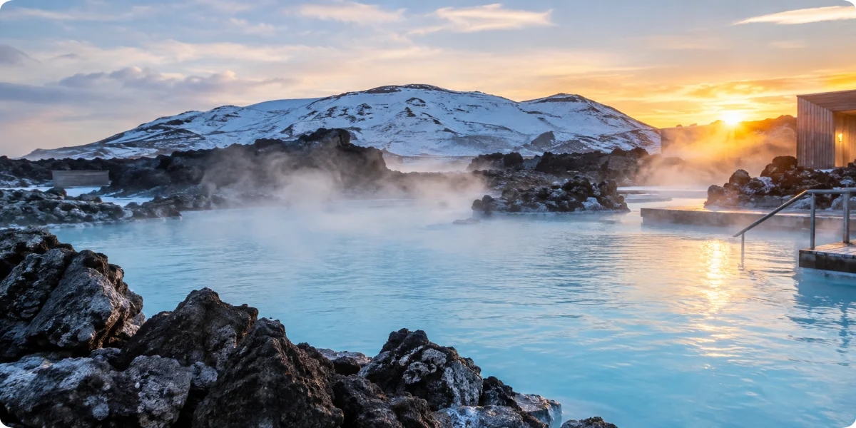 A serene geothermal pool at the Blue Lagoon in Iceland, illuminated by a vibrant sunset sky.