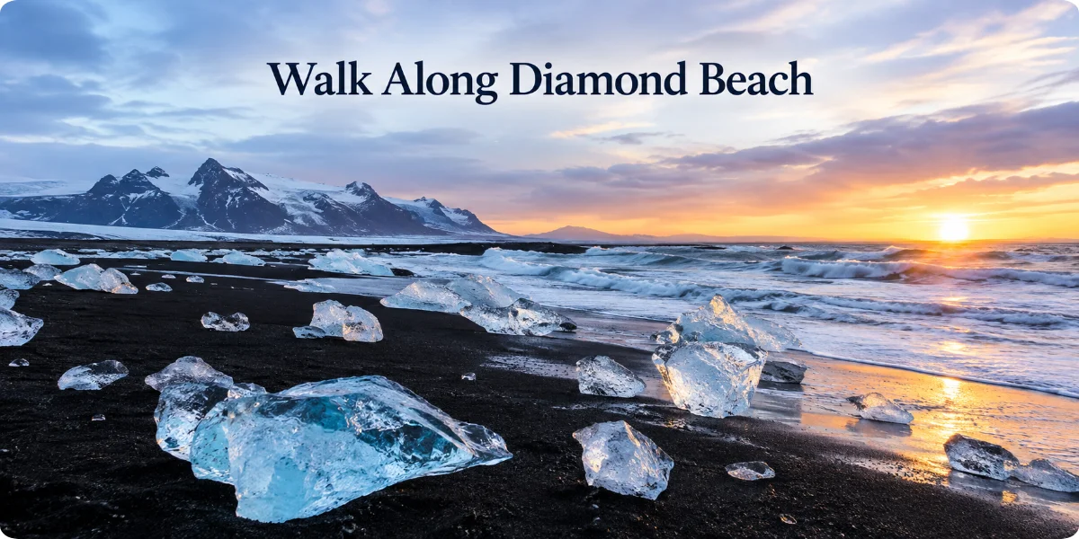 A scenic view of Diamond Beach, showcasing sparkling ice fragments on black sand with gentle waves lapping at the shore.
