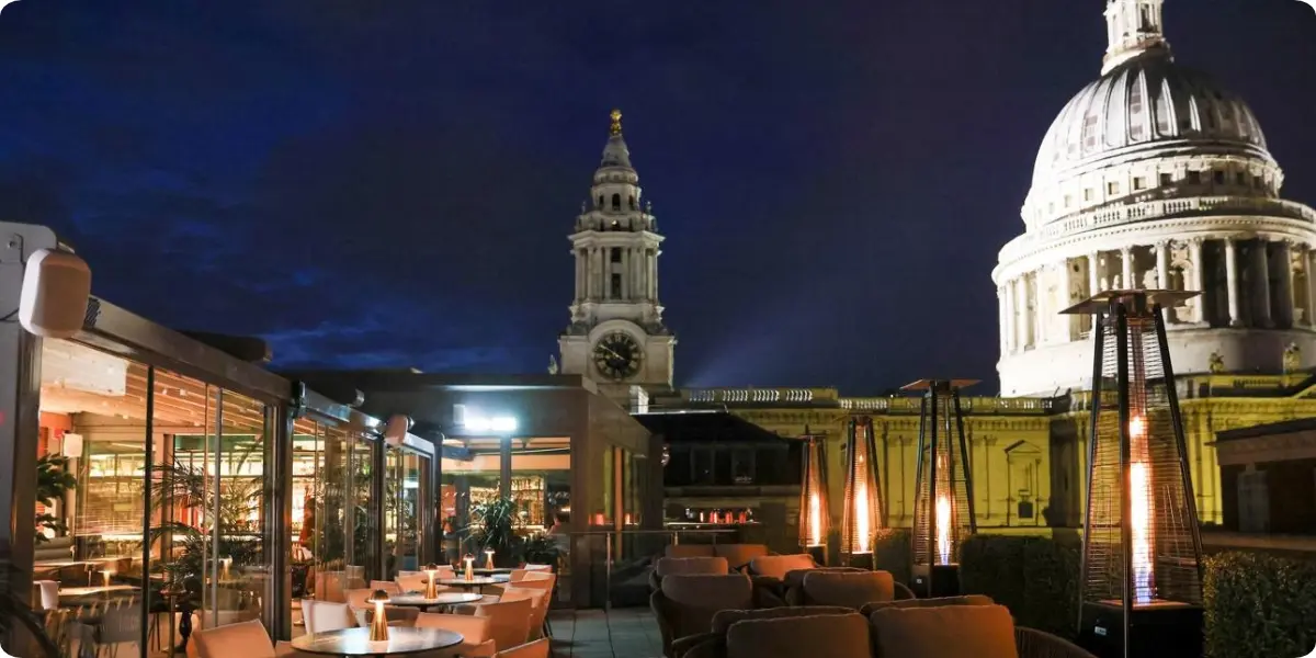Rooftop bar overlooking London's illuminated skyline at night