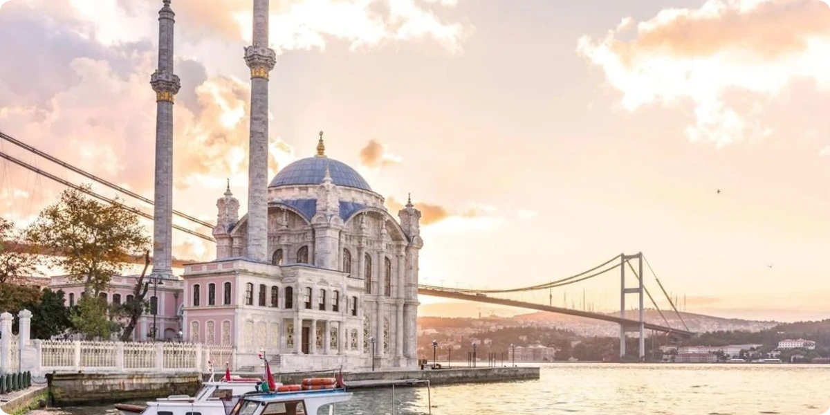 Ortaköy Mosque beside the Bosphorus Bridge in Istanbul at sunset.