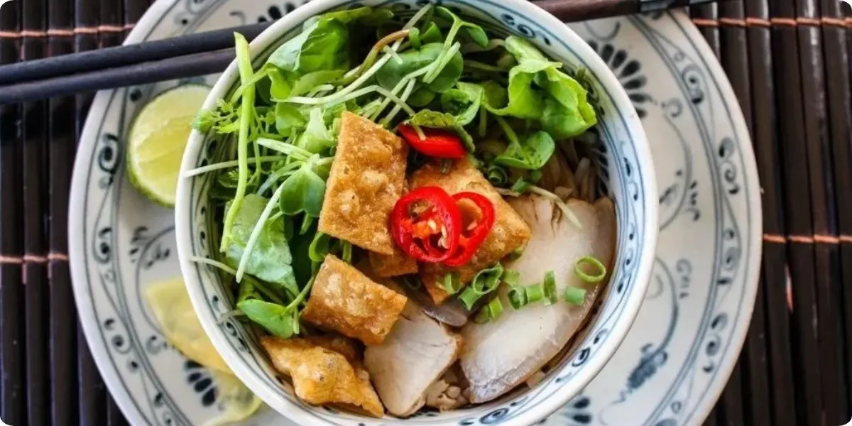 Traditional cao lau noodles with pork and fresh herbs in Hoi An Vietnam